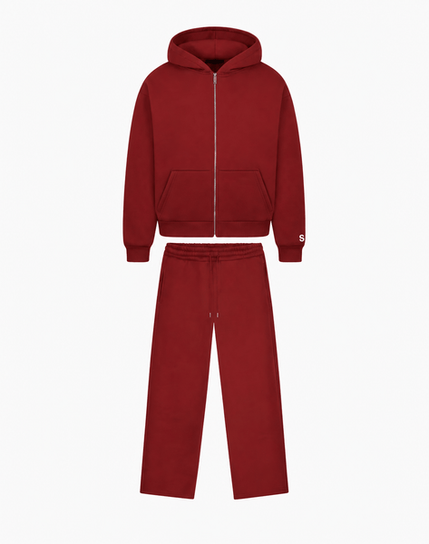 Bordeauxrotes Set aus Kapuzenjacke mit silbernem Reißverschluss und Fronttaschen sowie einer Hose mit weitem Bein auf weißem Hintergrund.